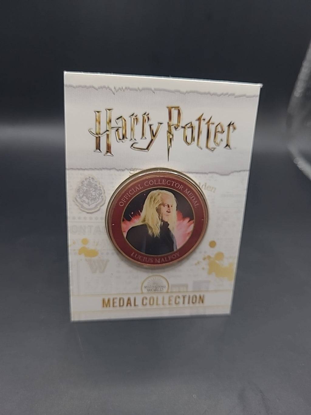 S6) RARE HARRY POTTER MEDAL COIN IN CARD LUCIUS MALFOY  JASON ISAACS JK ROWLING